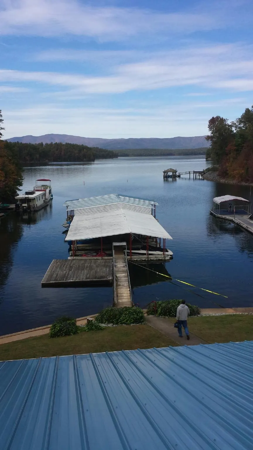 View across a lake from a newly installed blue metal roof in Winger