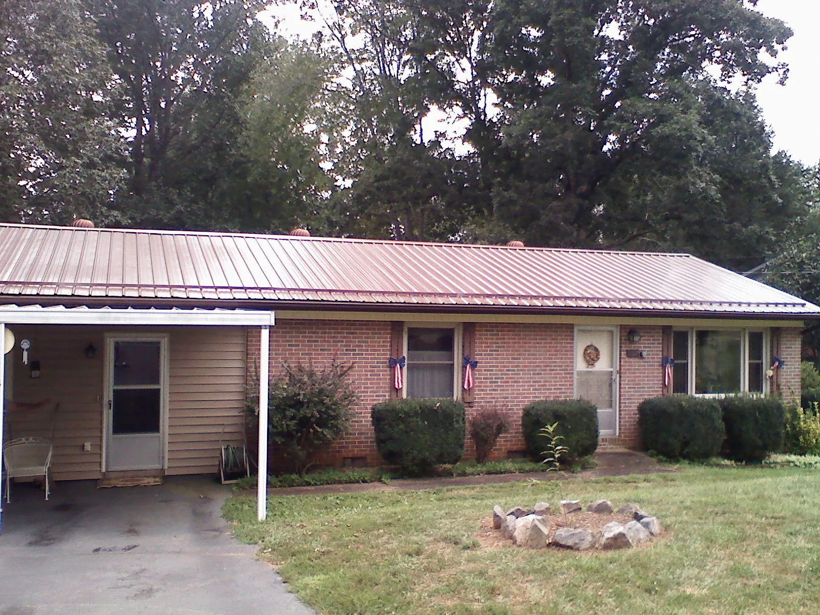 Bronze metal roof and carport on a brick ranch home — Roof Repair work by our crew in Winger